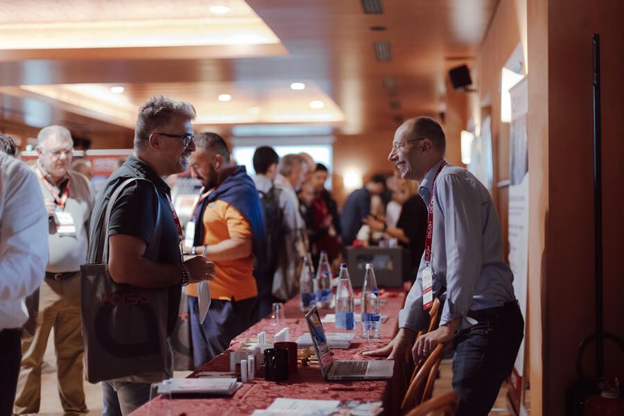 Trade fair with people discussing at an exhibition table.