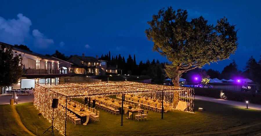 Beautiful outdoor dinner illuminated by twinkling lights on a summer evening.